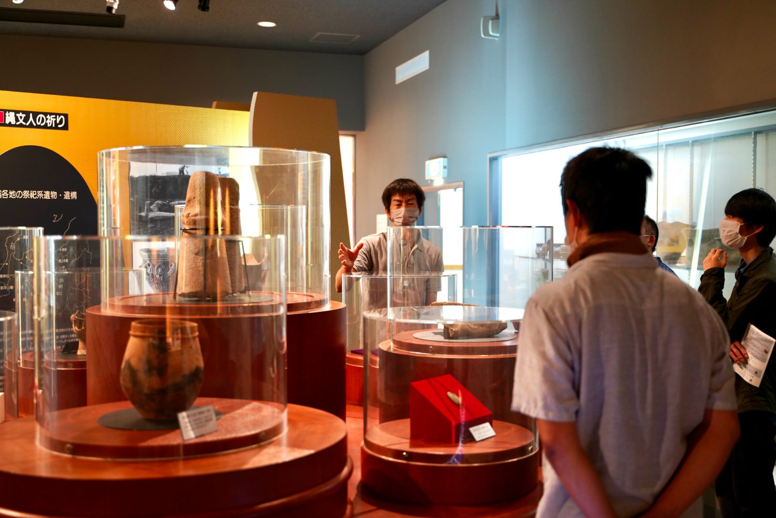展示室で来館者に解説する学芸員